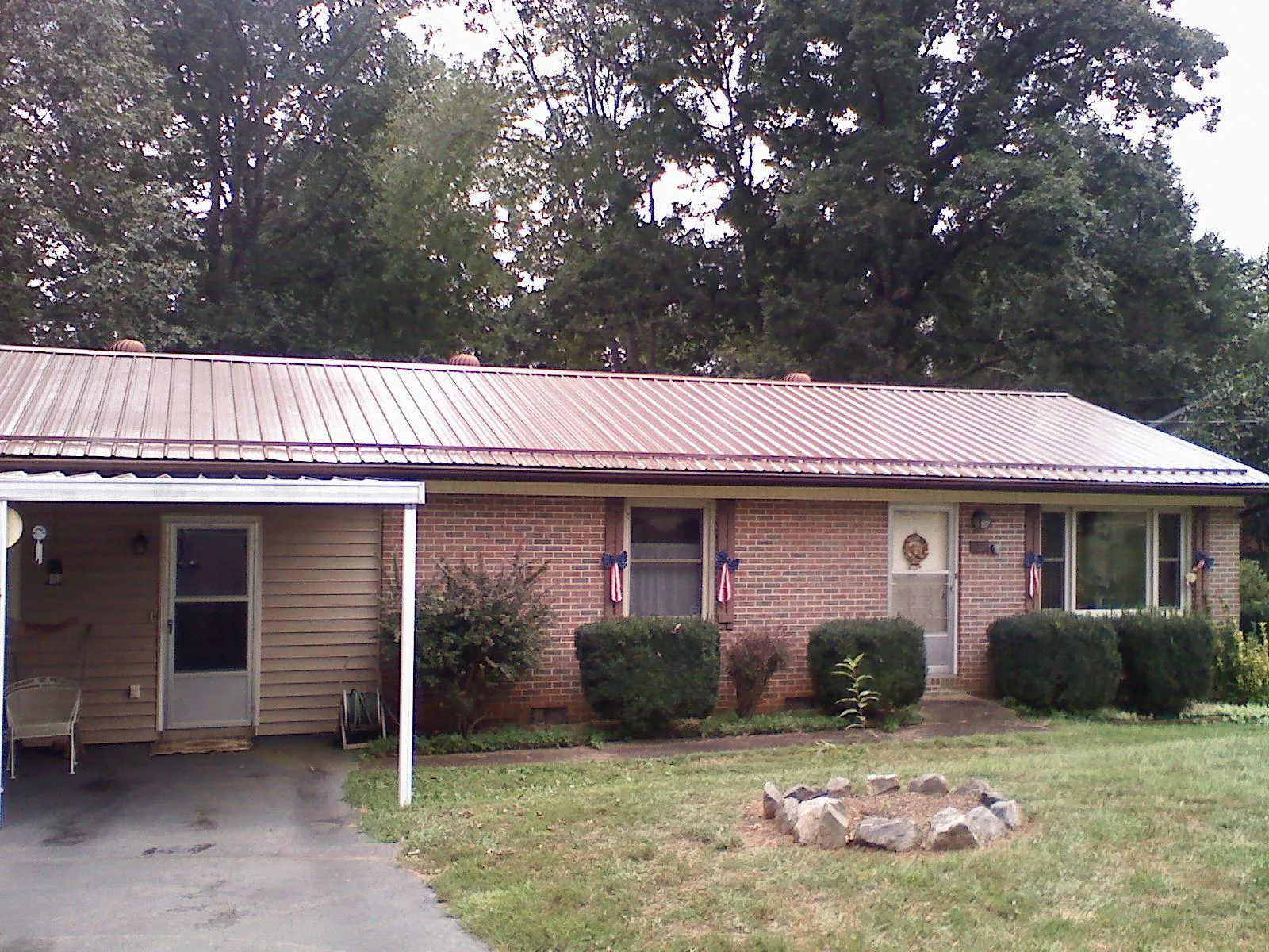 Bronze metal roof and carport on a brick ranch home — Roof Repair work by our crew in Hamilton